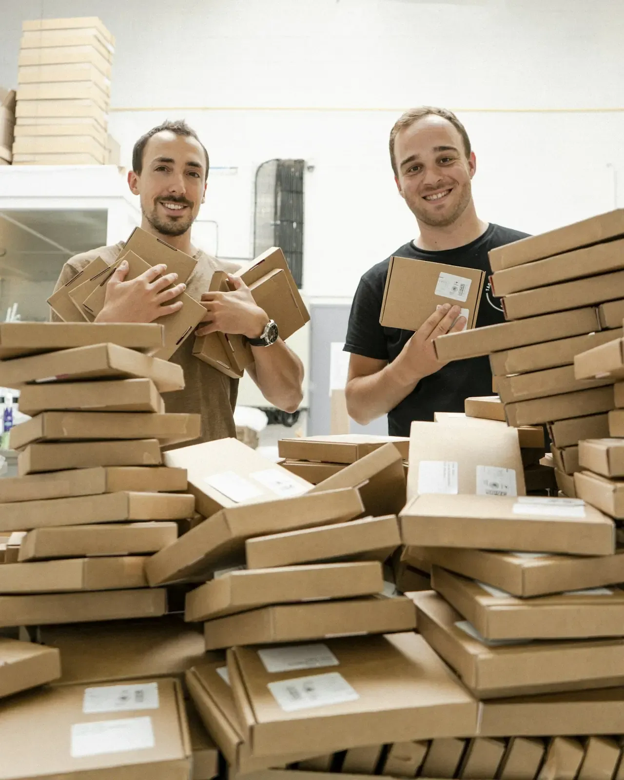 Two movers standing beside stacked boxes